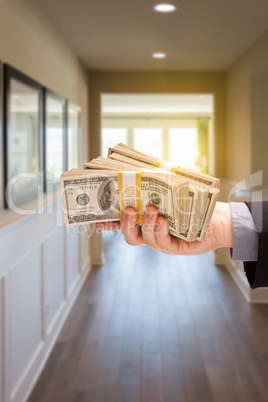 Male Hand With Stack of Cash Inside Hallway of House