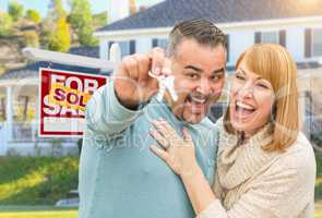 Mixed Race Couple With Keys in Front of Real Estate Sign and New