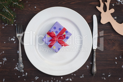 Packed gift on white empty plate, brown vintage in a festive tab