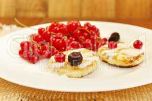 cheese cakes with berries of red currant black raspberry and sour cream