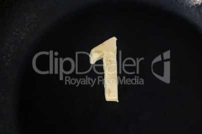 Butter in shape of number 1 on hot pan - Close up top view