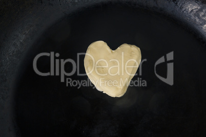 Butter in shape of heart on hot pan - Close up top view
