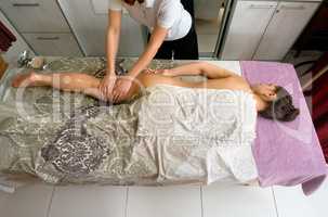 Young woman at massage therapy in spa centre