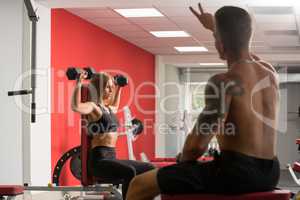 Sportive woman with trainer at gym