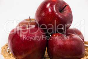 Close up of ripe red apples in wicker basket isolated on white b