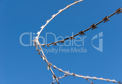 Barbed wire against the blue sky
