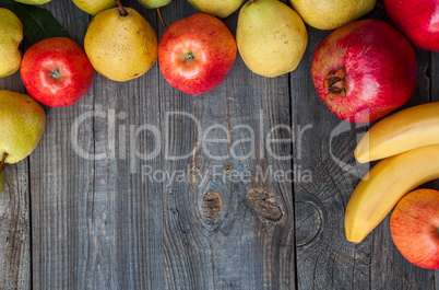 Ripe fruits lined frame on a gray wooden surface, empty space in