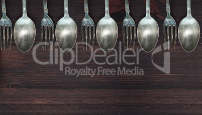 Wooden background with vintage spoons and forks