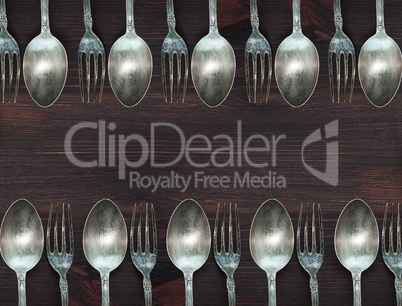 Wooden background with vintage spoons and forks