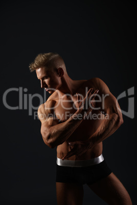 Sexy bodybuilder in briefs posing in his profile