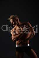 Sexy bodybuilder in briefs posing in his profile