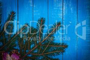 Blue wooden festive background with spruce branch in the corner