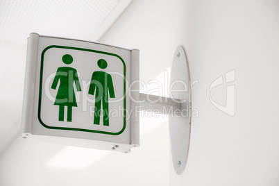Public modern white and green restroom sign on white wall