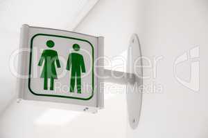 Public modern white and green restroom sign on white wall