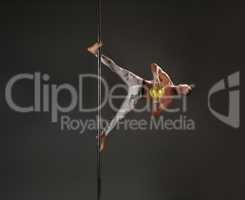Male dancer at pylon in pole dance studio