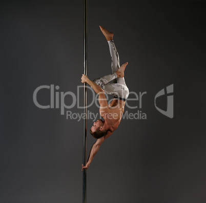 Male dancer at pylon in pole dance studio