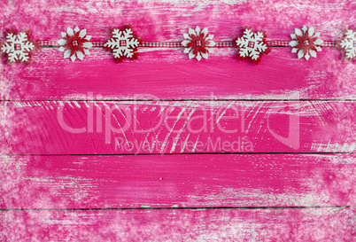 Wooden shabby pink background with garland of felt snowflakes