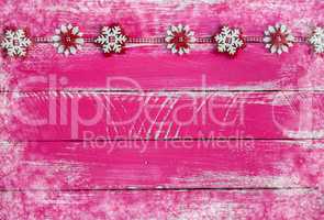 Wooden shabby pink background with garland of felt snowflakes