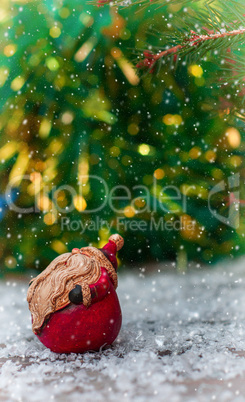 Ceramic Santa Claus on a small snow-covered wood surface