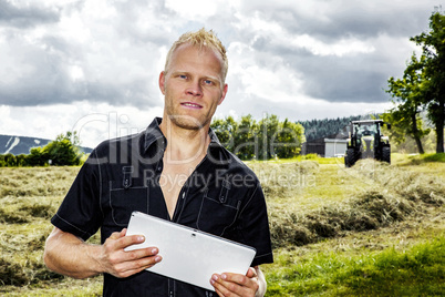 Man with tablet PC in haymaking