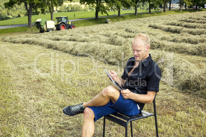 Man with tablet PC in haymaking