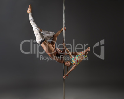 Pole dancers making exercises in pair studio shot