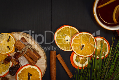 Black tea in a mug with dried and fresh citrus fruit