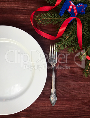 white empty plate with  fork on a table