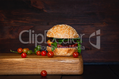 Beef Burger with cutlet and vegetables served on a chopping boar