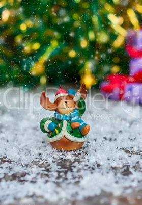 Ceramic Christmas toy elk in festive clothes standing in the sno