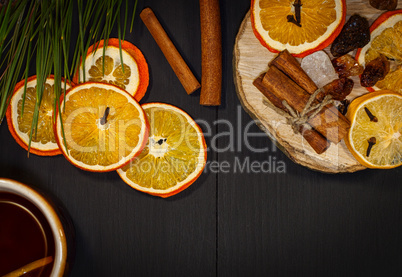 Black tea in a mug with dried and fresh citrus fruit