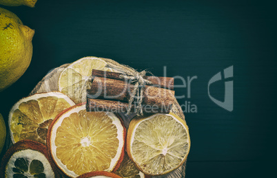 Citrus and cinnamon on the black wooden background