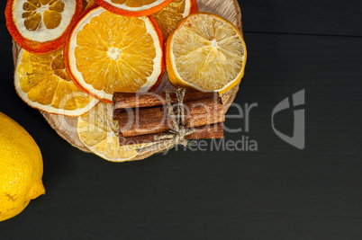 Citrus and cinnamon on the black wooden background