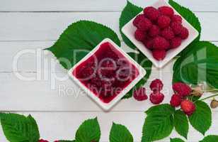 Raspberry jam and fresh raspberries ripe in the saucer