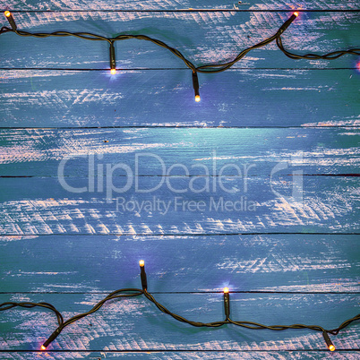 Blue wooden background with electric garland