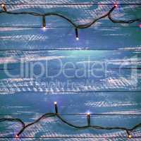 Blue wooden background with electric garland