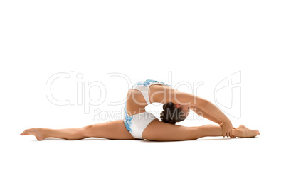 Young female gymnast stretching on white