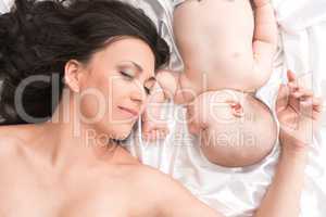 Young mom with newborn baby sleeping in bed