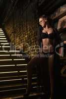 Seductive beauty in black lingerie on stairs