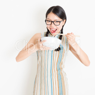 Oriental girl eating with chopsticks