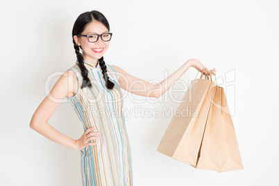 Oriental female holding shopping paper bag