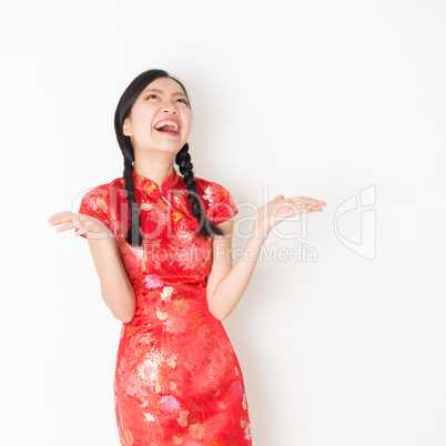 Surprised oriental girl in red qipao