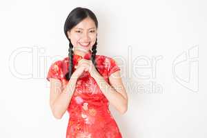 Oriental girl in red qipao greeting