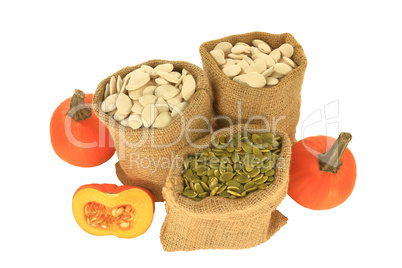 Pumpkin seeds with and without shell in burlap bags, pumpkins