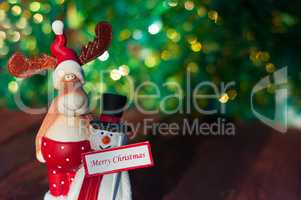 Christmas toy elk and snowman on green blurred background