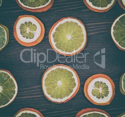 Dried slices of orange and lemon on a brown wooden surface