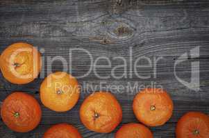 orange mandarins on the gray wooden background, top view