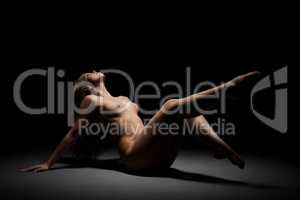Naked woman posing at black studio background