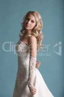 Young  bride in wedding dress posing on studio background