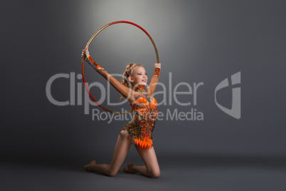 Gymnast girl performing with hoop at studio